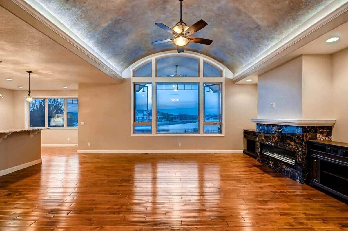 Great room with a barrel-vaulted ceiling and a marble fireplace flanked by base cabinets.