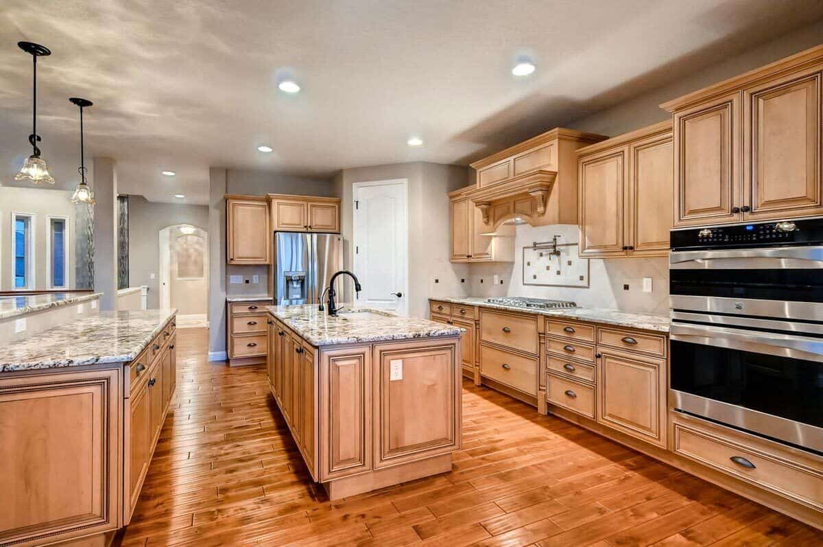 The kitchen includes double wall ovens and a sink fitted on the center island.