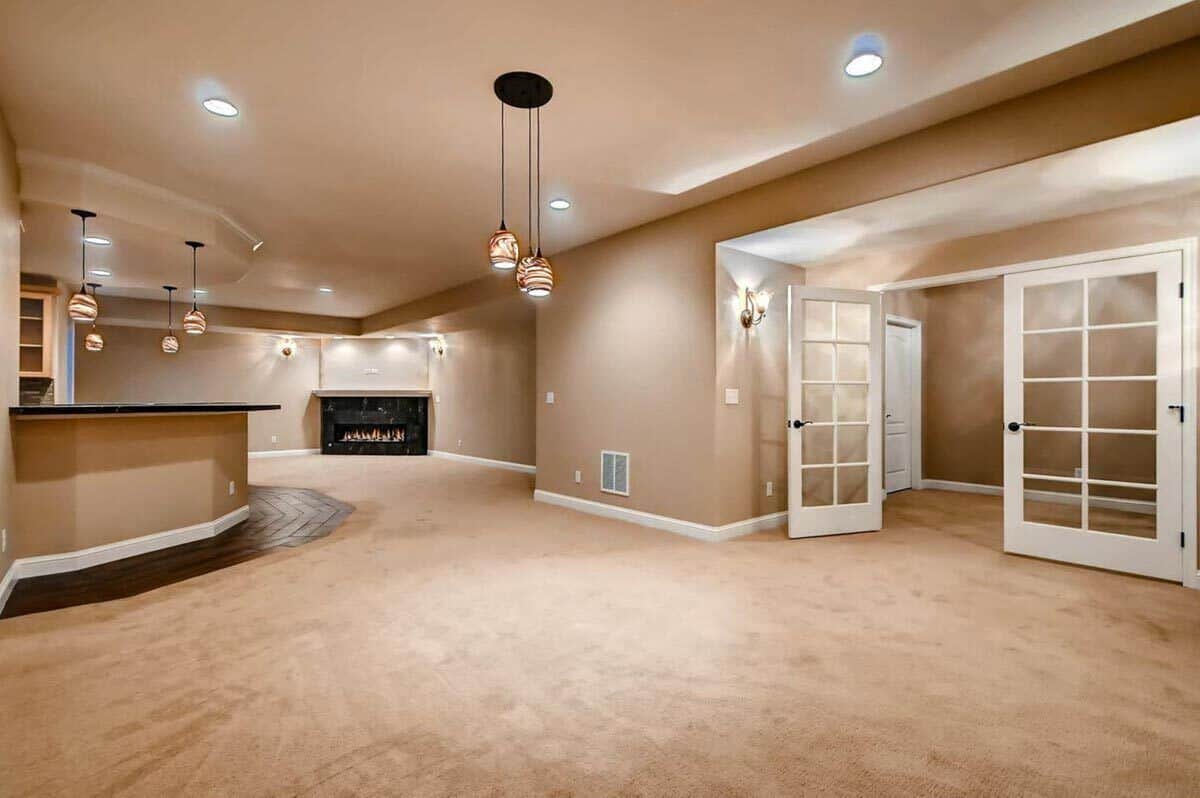 Basement with a French door, a marble fireplace, and a wet bar.