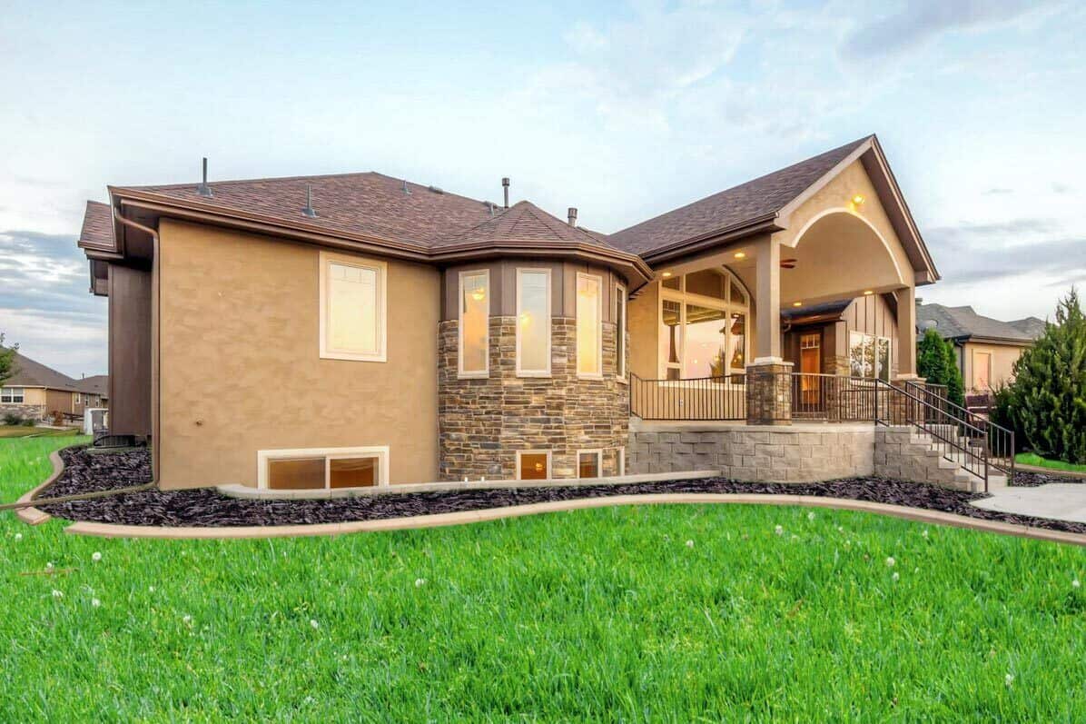 Angled rear view showcasing the gabled porch and basement windows.