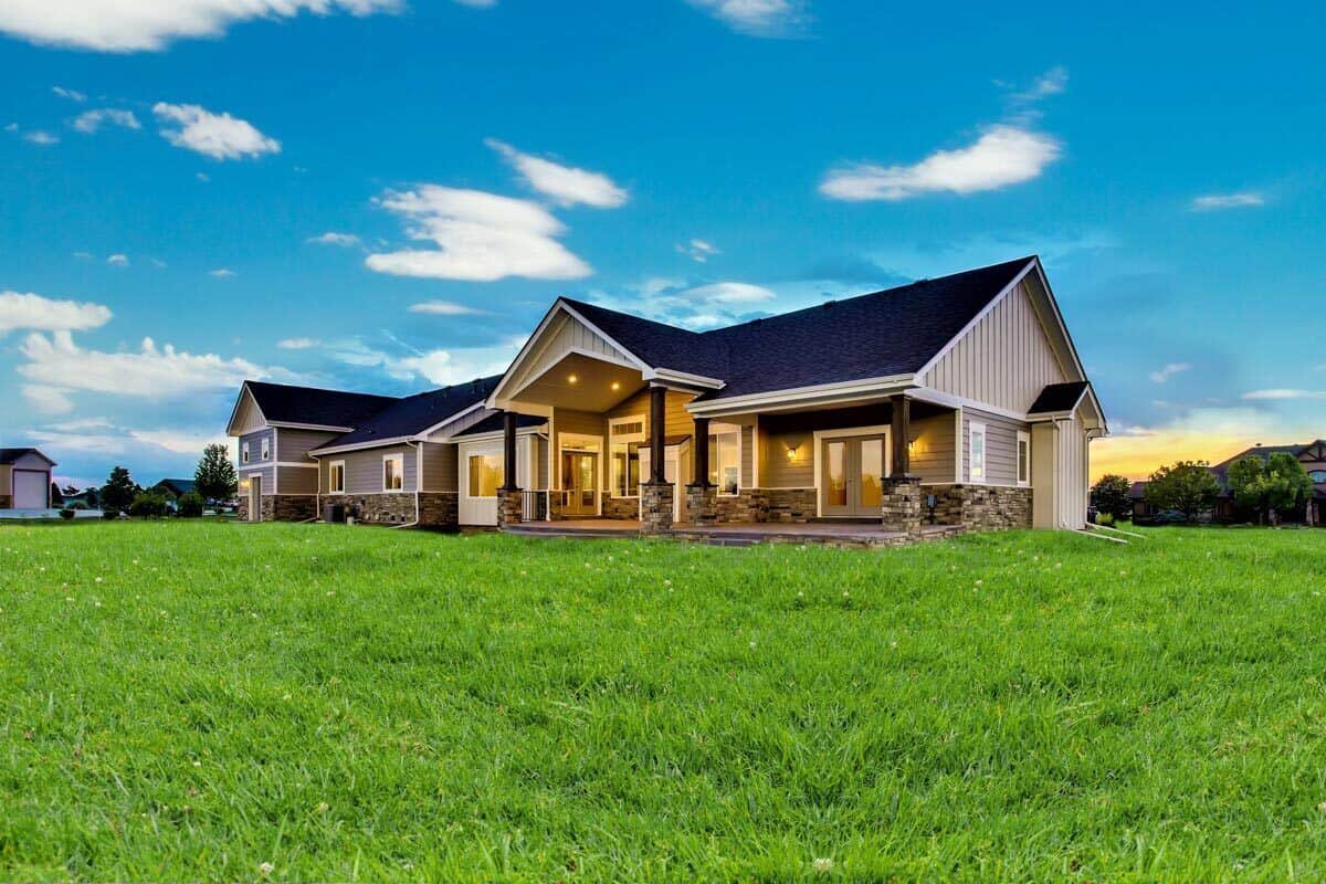 Rear view of the house showcasing the expansive patio supported by stone base columns.