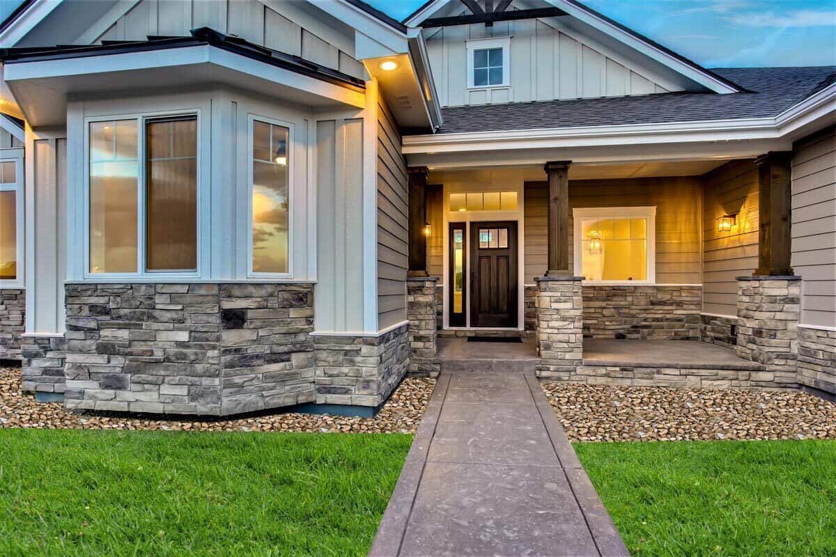 Front porch with stone base columns and a wooden entry door.