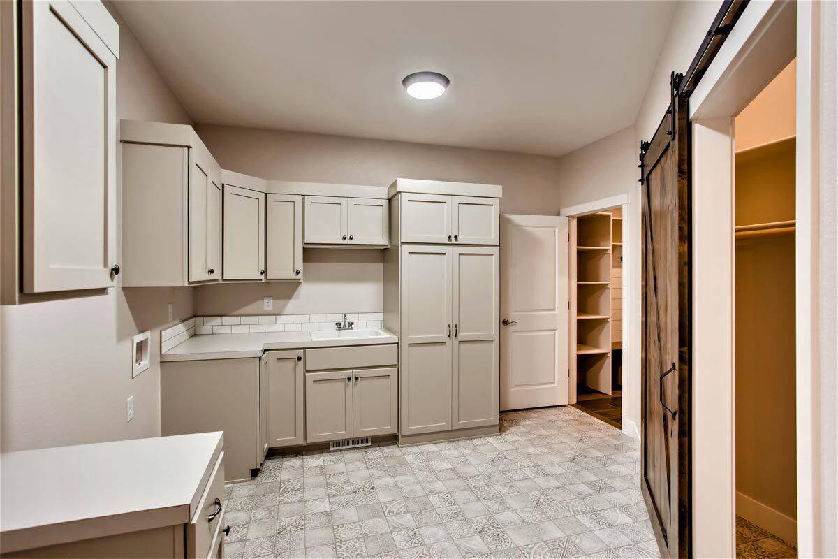 Laundry room with additional storage, a sink, and multiple counter spaces.