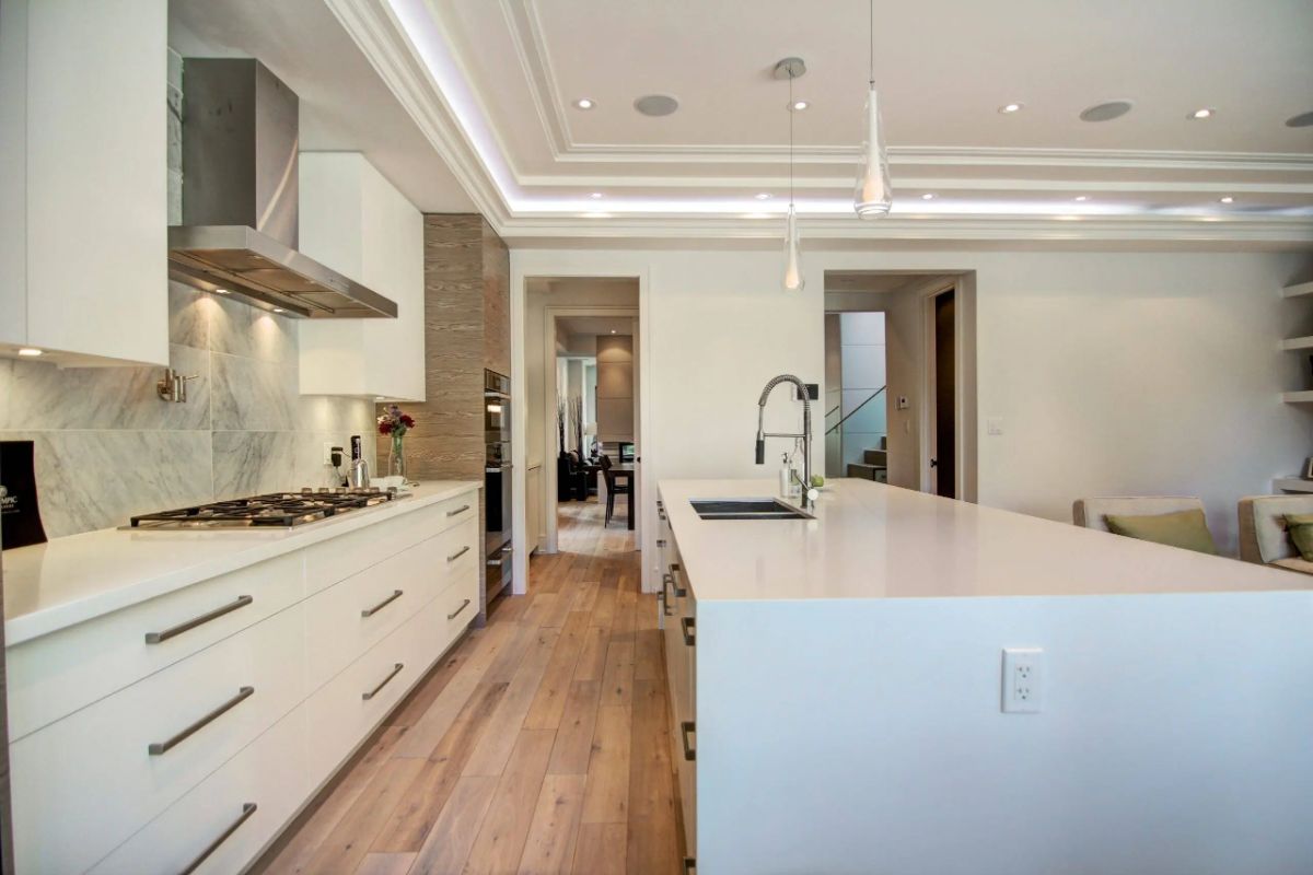 Kitchen with a white counter top and wooden floors.