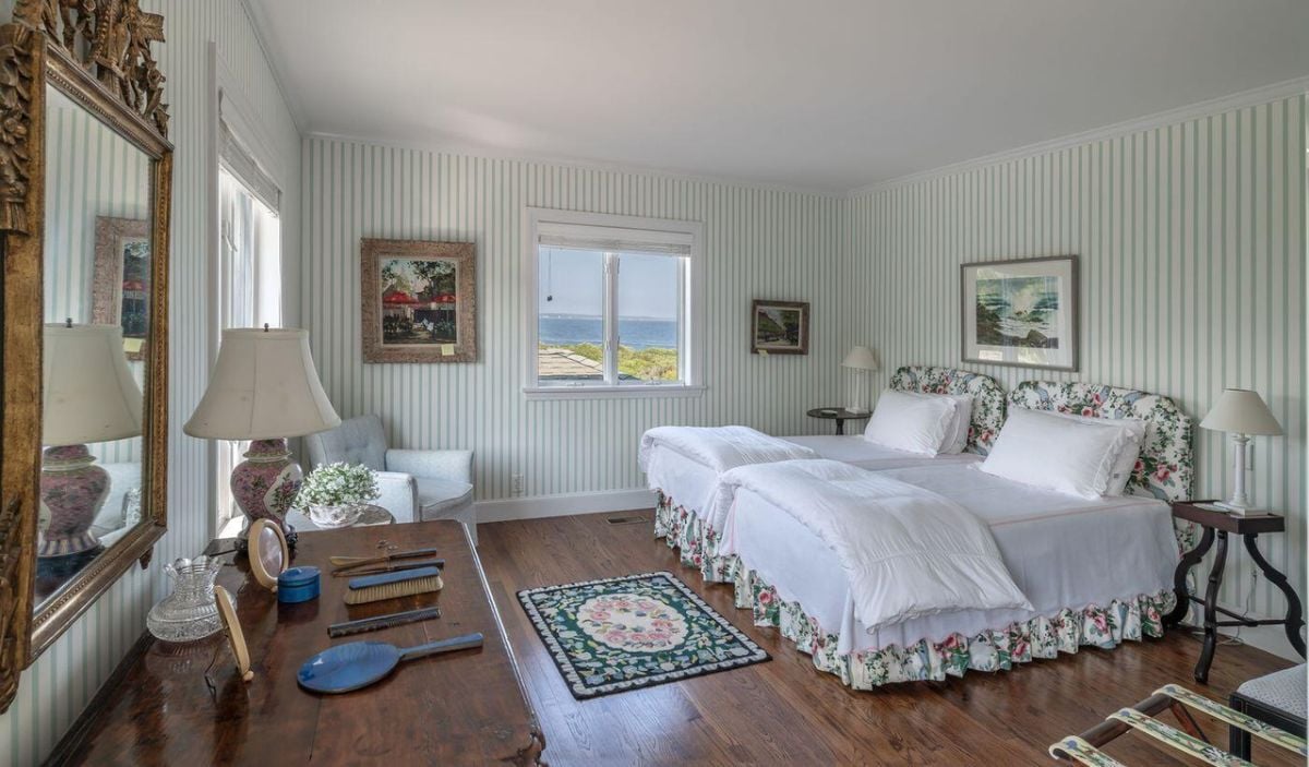 Bedroom with wood flooring, two beds and glass windows.