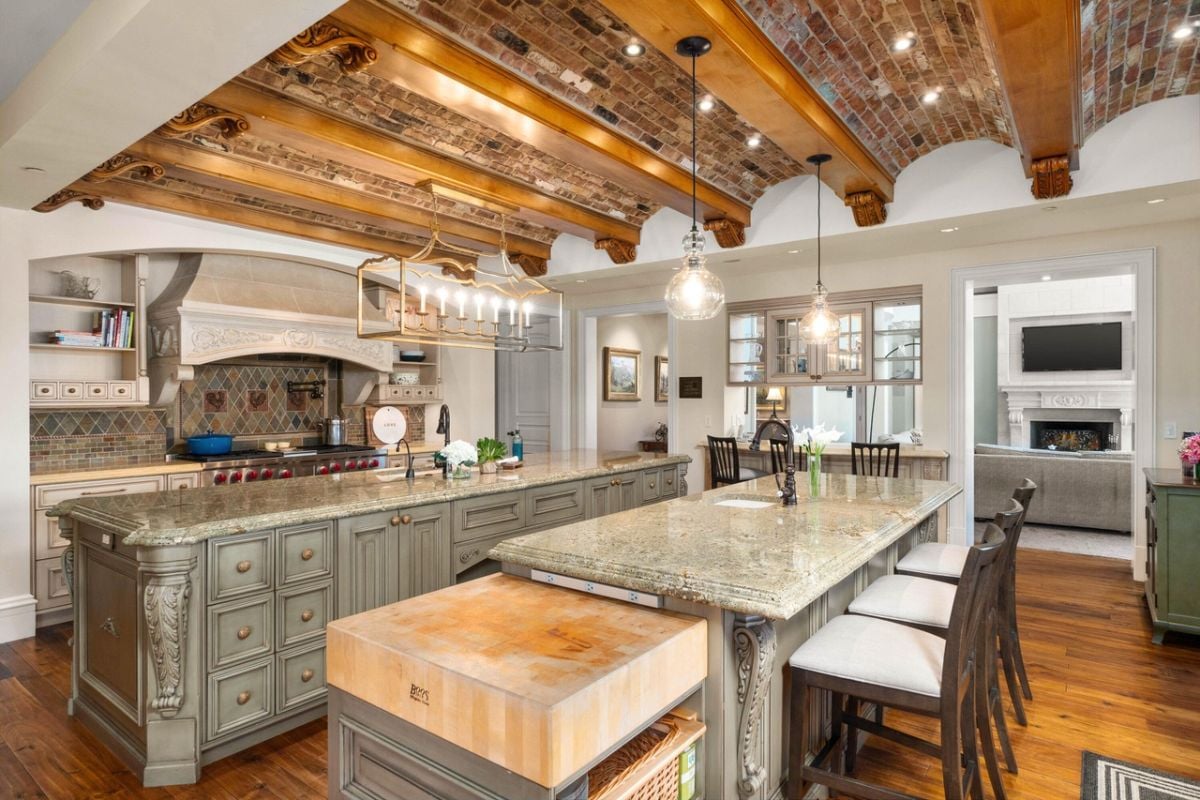 Kitchen with a large island, custom lighting, and wooden beams.