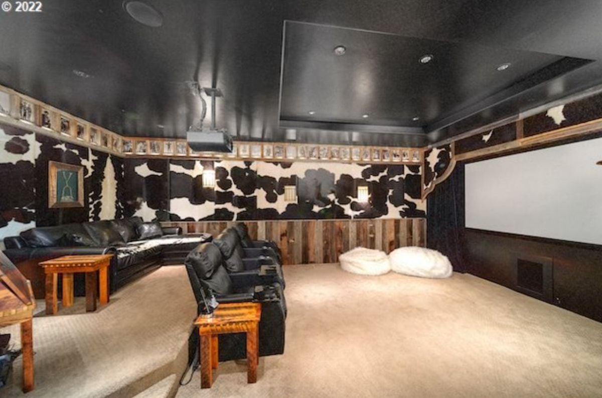Media room with leather couches and carpet flooring.