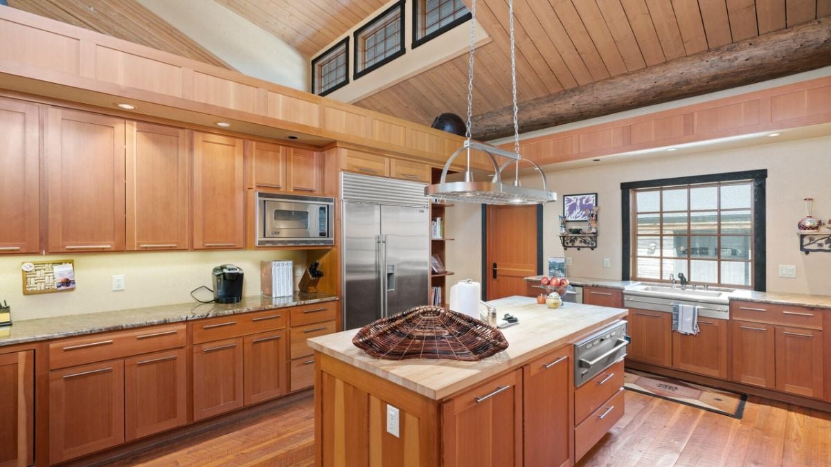 Kitchen with stainless steel appliances, wood flooring and custom cabinetry.
