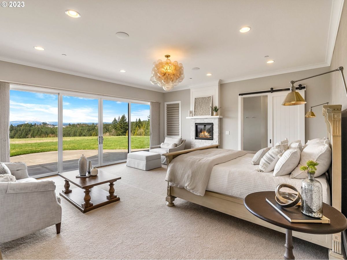 Bedroom with carpet flooring, custom lighting and large glass doors.