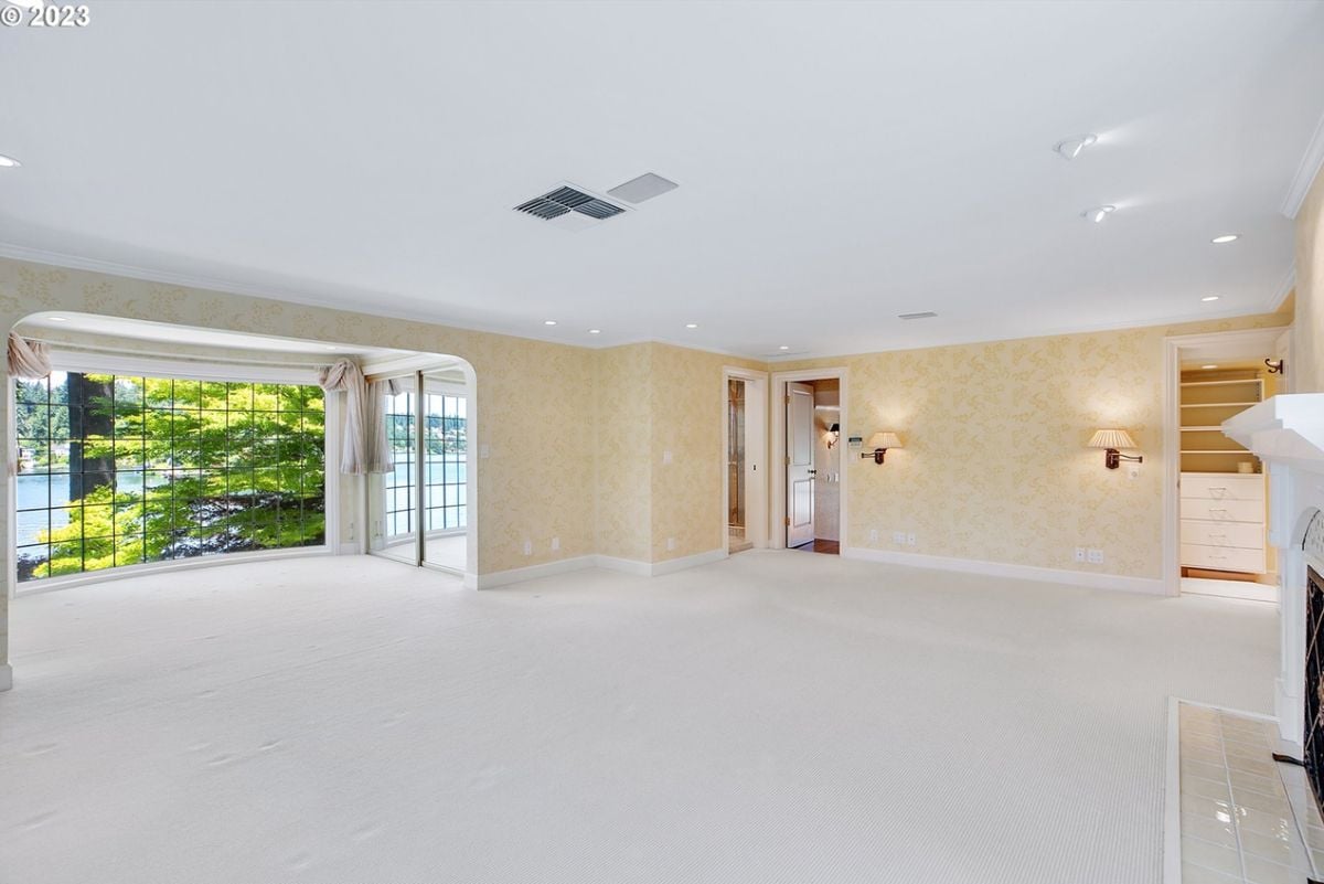 Master bedroom with carpet flooring, a fireplace and bathroom.