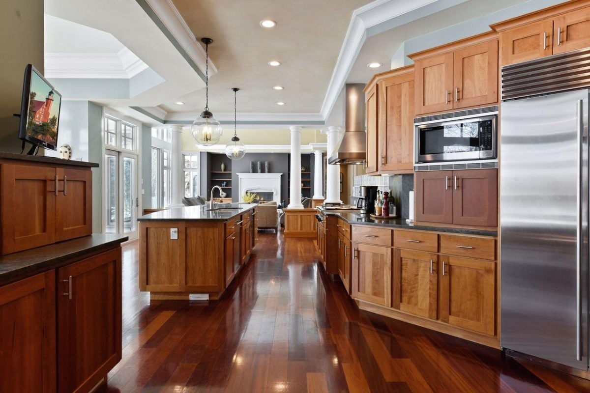 Kitchen with wood flooring, custom cabinetry, and custom lighting.
