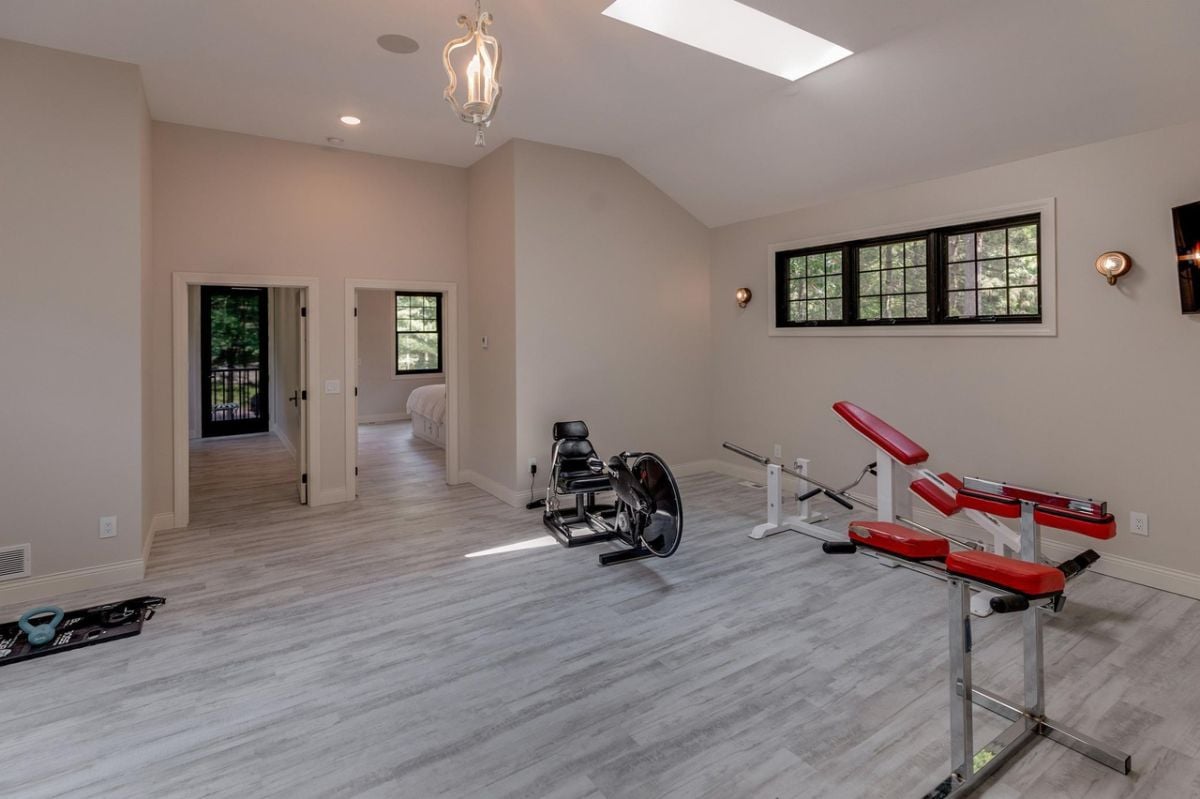 Home gym with workout equipment and skylight.