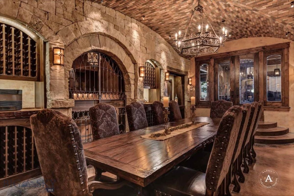 Dining room with chandelier, a large wooden table and chairs.