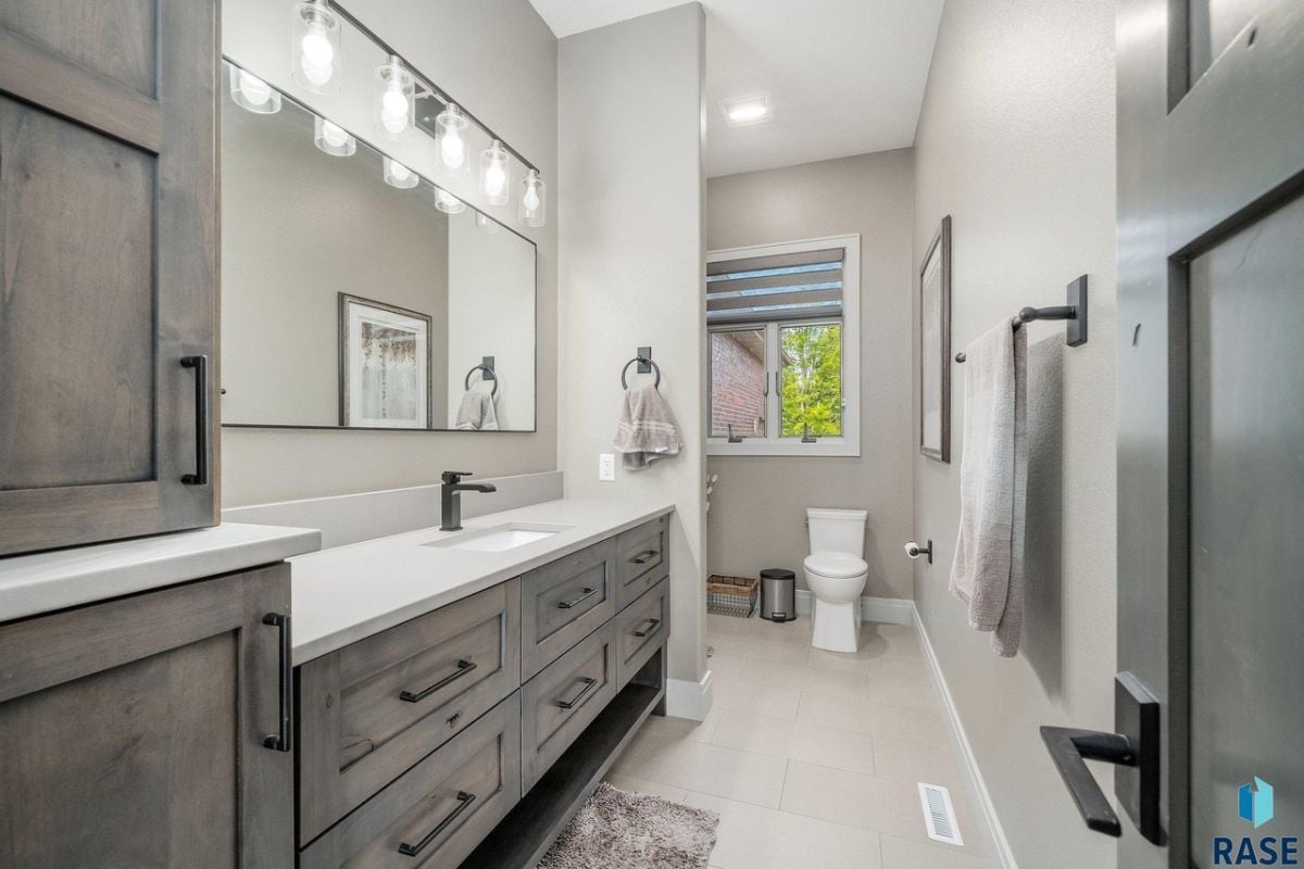 Bathroom with a sink, custom lighting and a toilet.