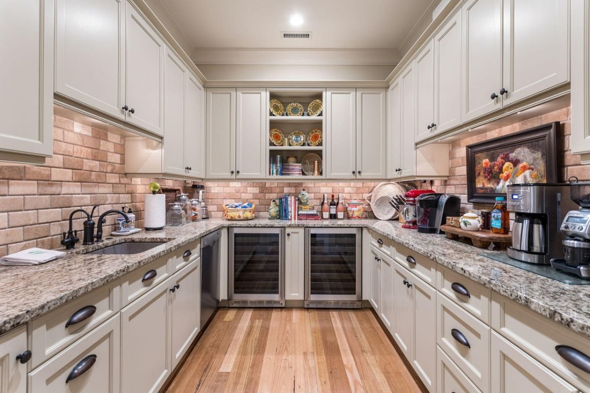 Pantry with marble countertops and custom cabinetry.