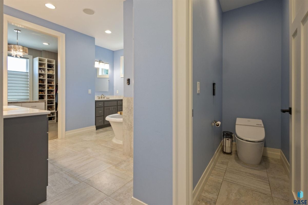 Bathroom with tile flooring, a walk-in closet, and a toilet.