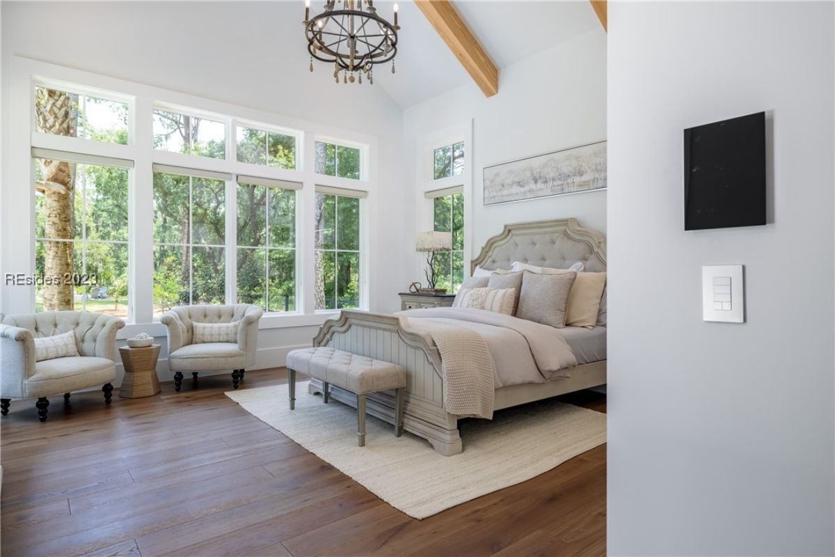 Bedroom with wood flooring, couches, and glass windows.