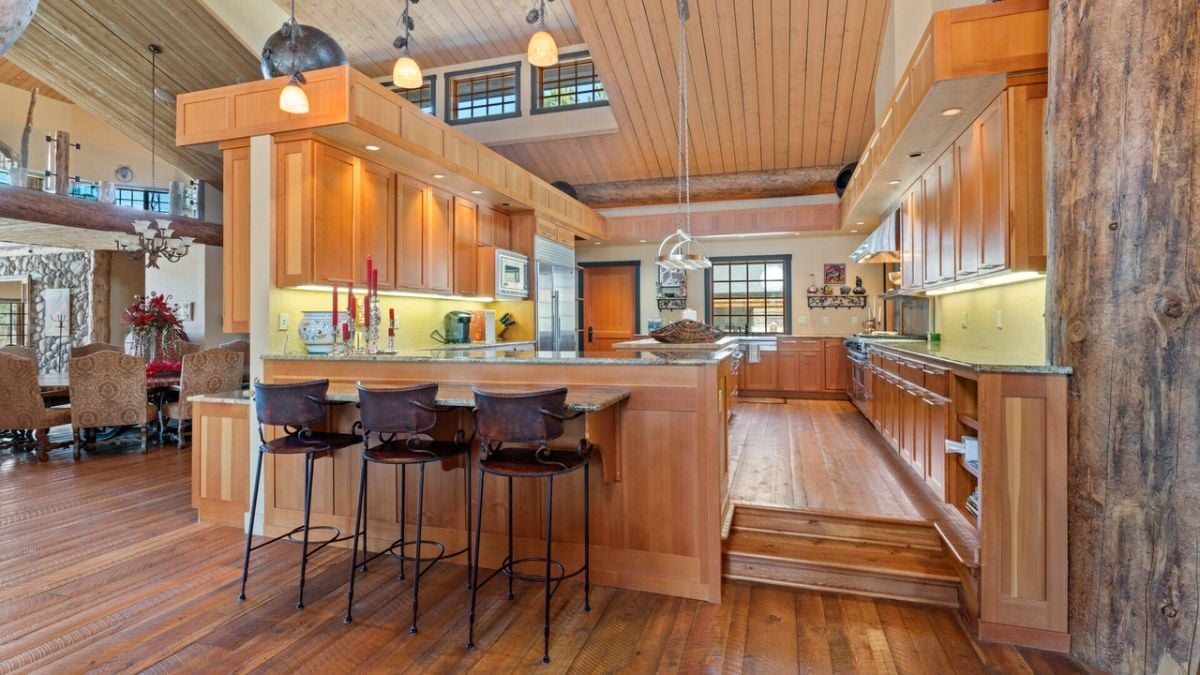 Kitchen with custom lighting, wood flooring and custom cabinetry.