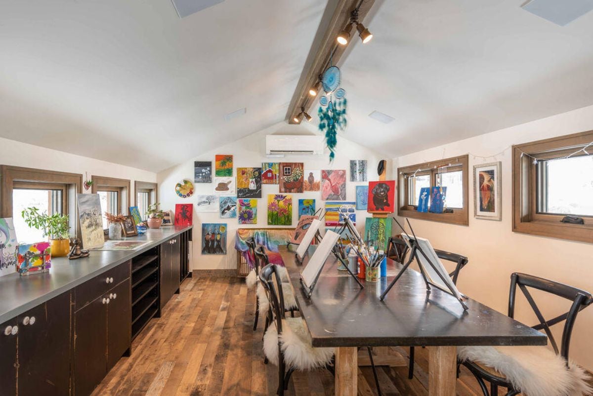 Art room with paintings and custom lighting.