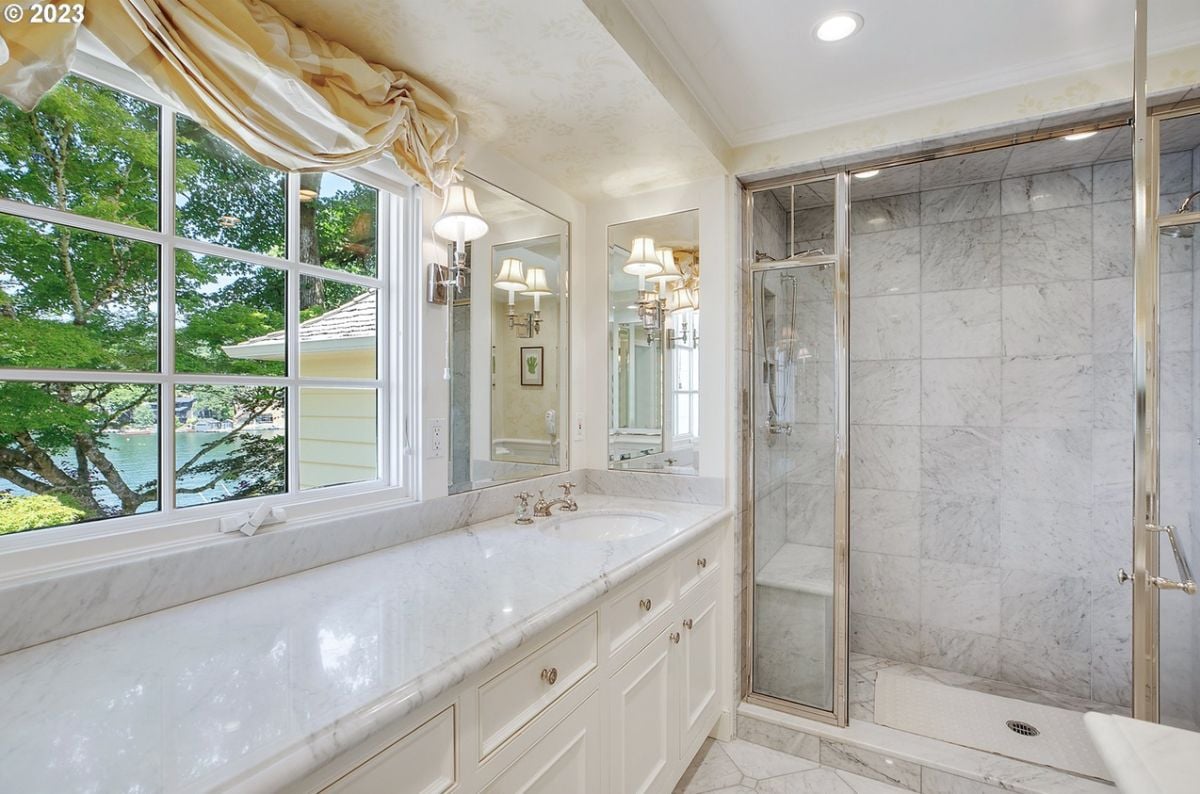 Bathroom with sink, glass windows, and shower.