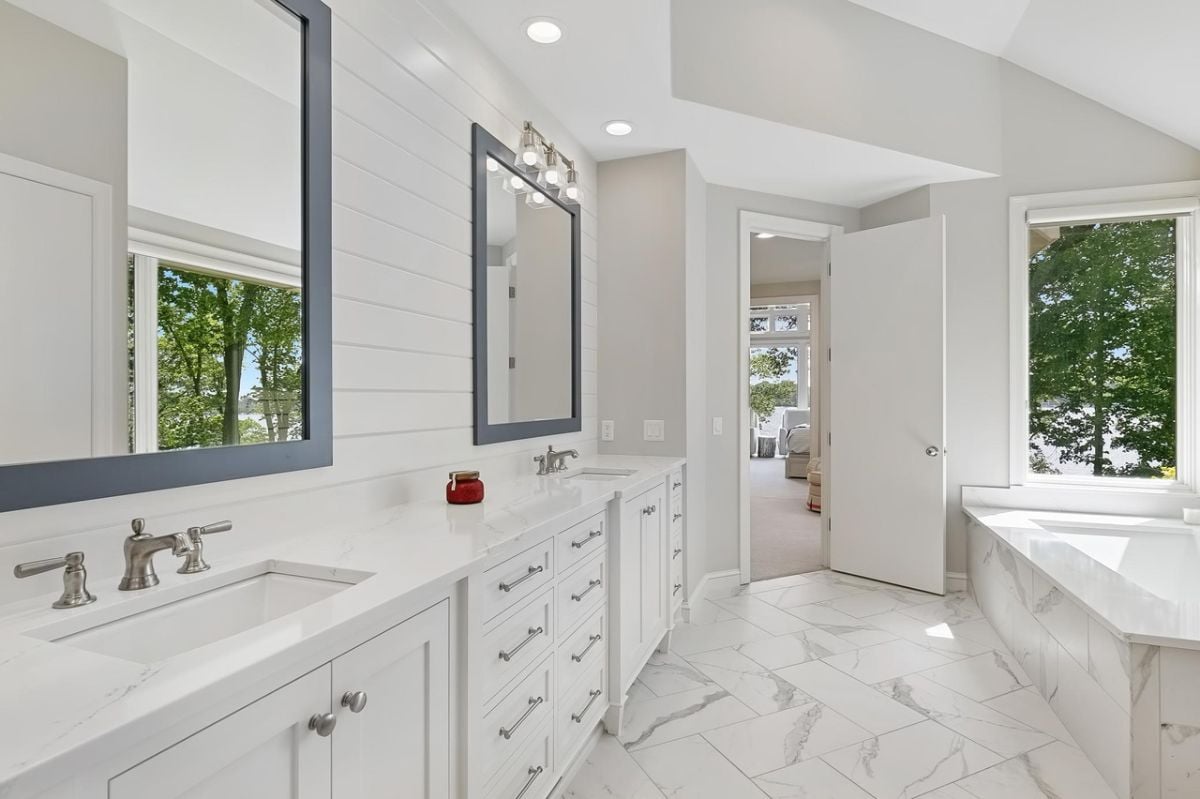 Bathroom with sinks, drawers, and soaking tub.