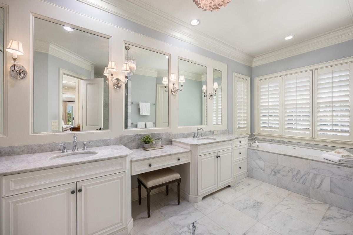 Bathroom with tile flooring, sinks, custom lighting and a bath tub.