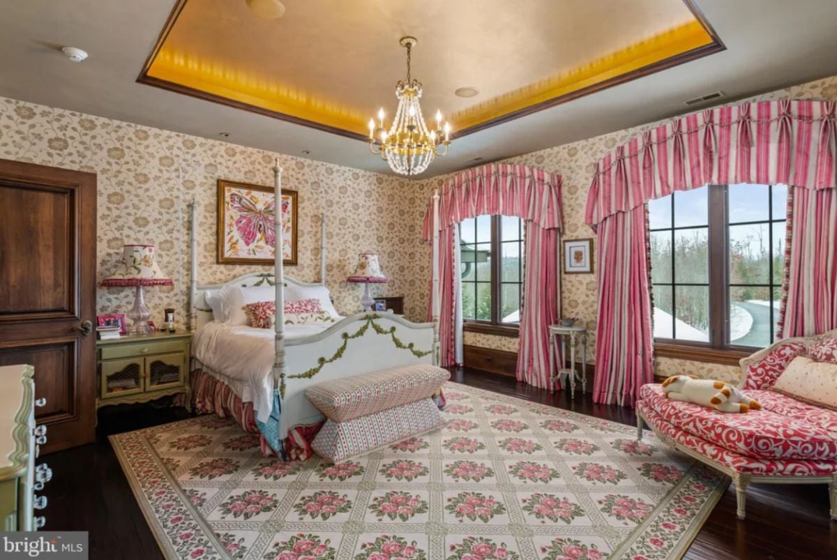 Bedroom with a chandelier, a large rug and glass windows.