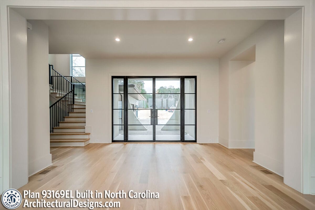 Foyer with hardwood flooring, a French entry door, and a staircase leading to the secondary bedrooms.