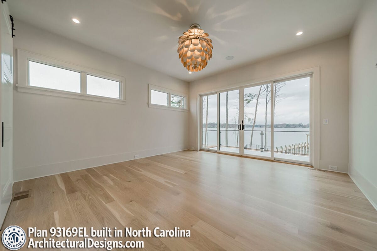 Primary bedroom with clerestory windows and a private balcony accessible through sliding glass doors.