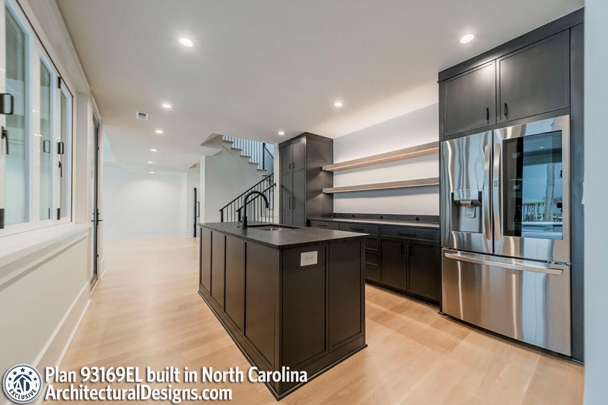 Wet bar with black cabinets and modern appliances.