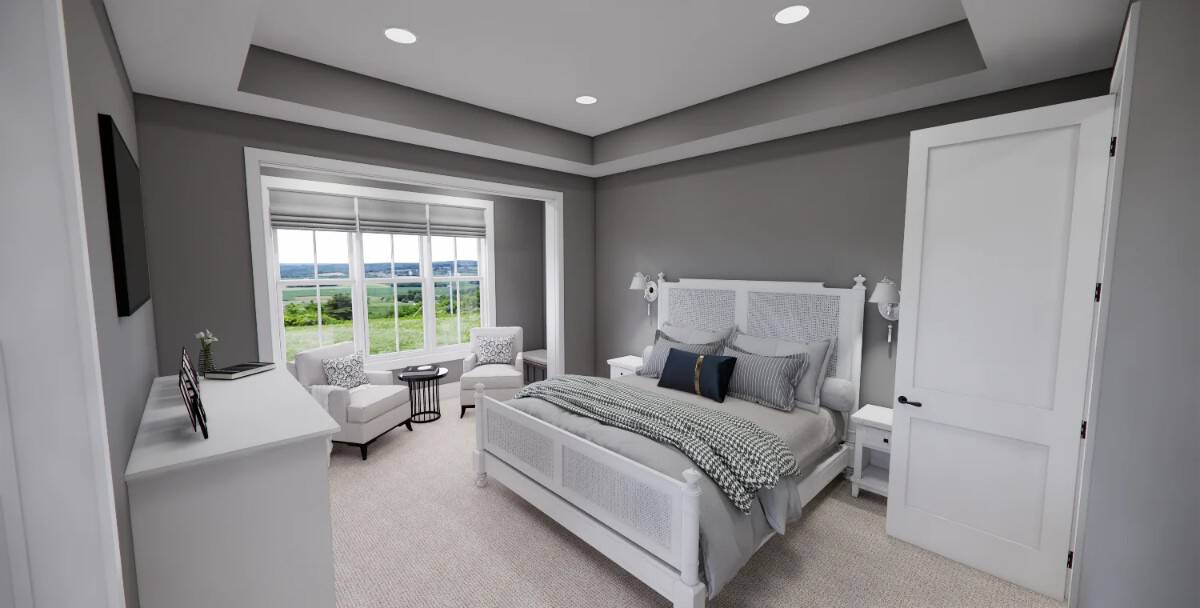 Primary bedroom with a tray ceiling and a sitting area by the huge windows.