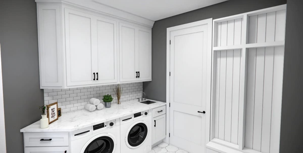 Laundry room with white cabinets, marble countertops, and front-load washer and dryer.