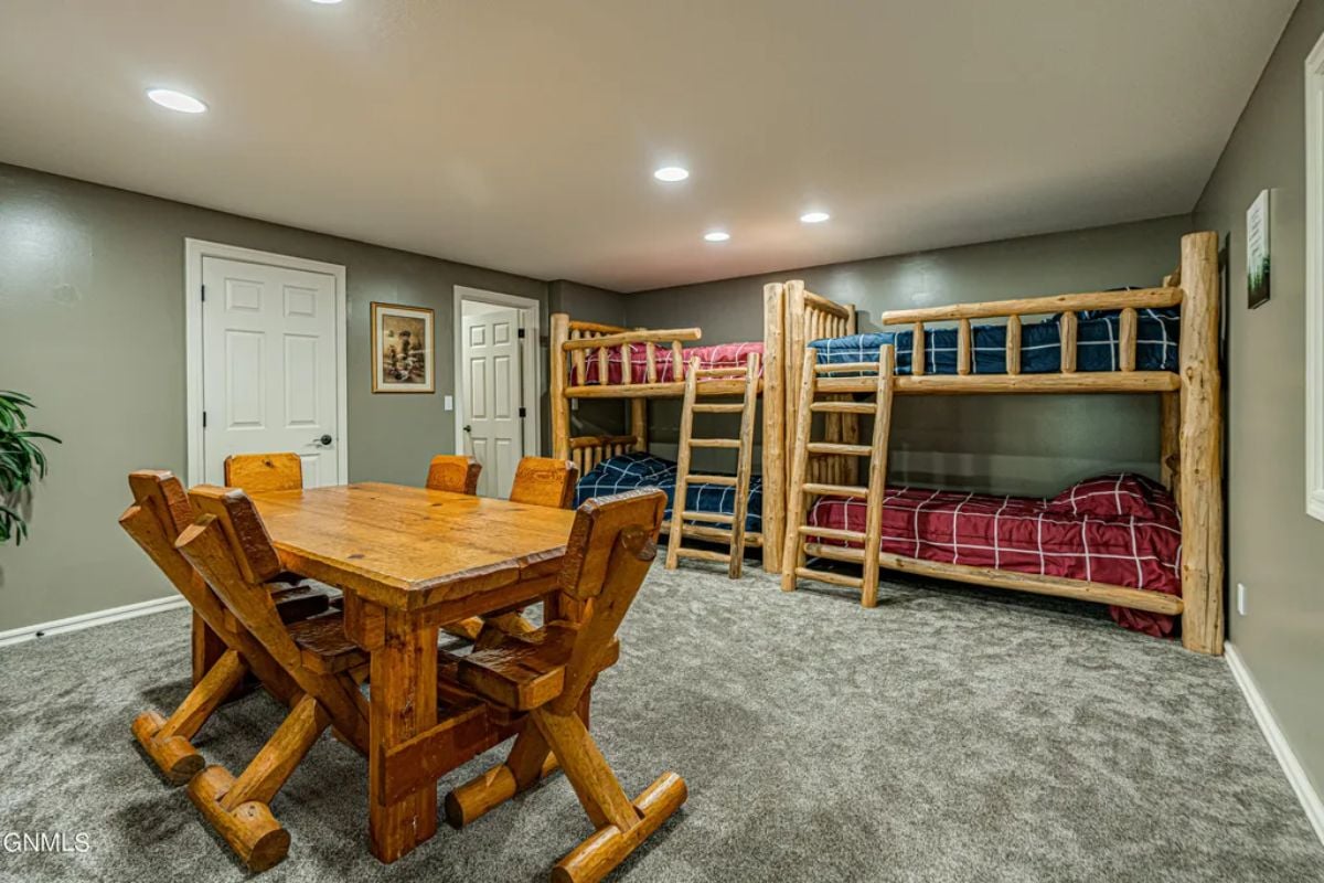 Bedroom with 2 double decks, chairs and table.