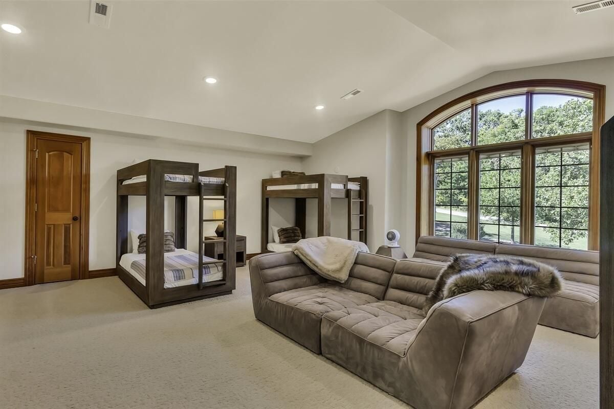 A double deck and a couch in a bedroom.