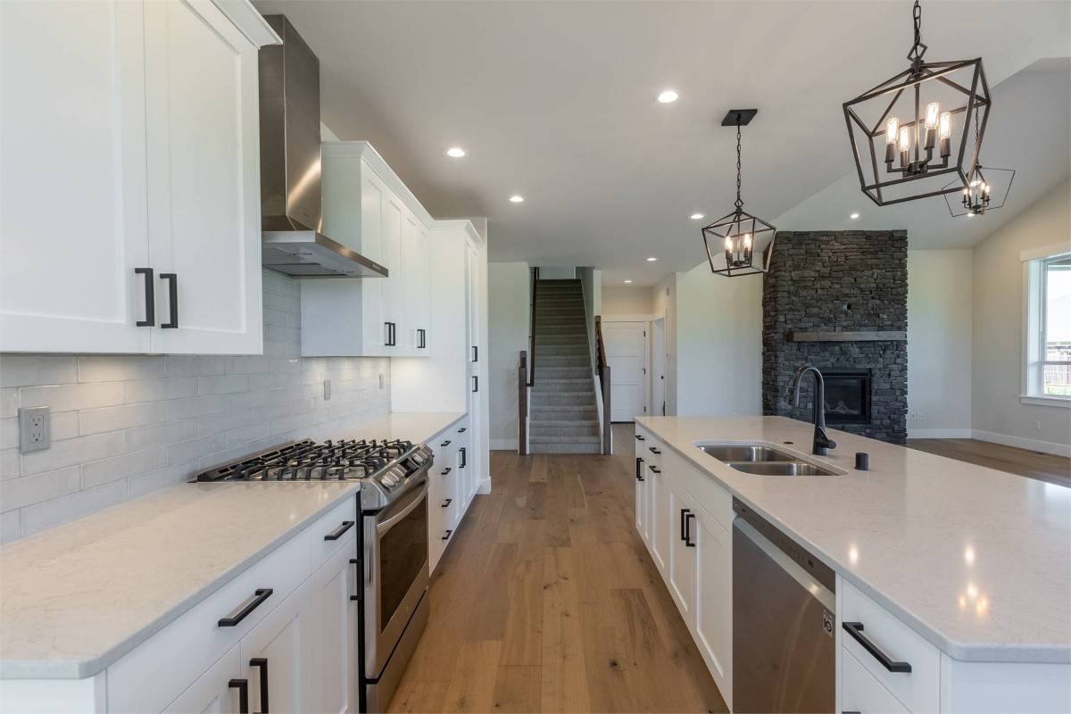 Recessed ceiling lights and caged pendants suspended over the island illuminate the kitchen.