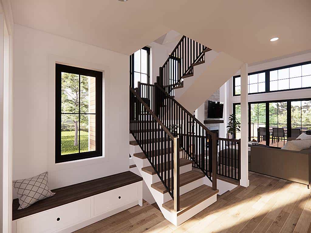 Foyer with a built-in bench and a staircase that blends in with the hardwood floor.