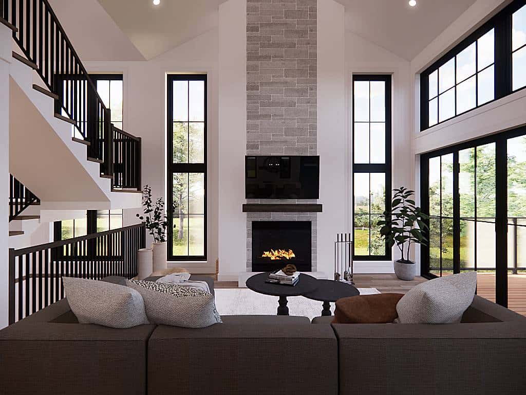 Living room with a modern sectional, nesting coffee tables, and a modern fireplace topped with a TV.