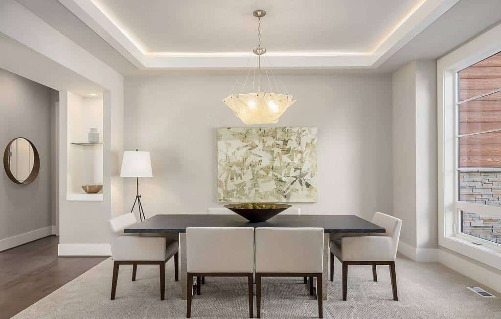 Formal dining room with a niche wall and a modern dining set under a tray ceiling.