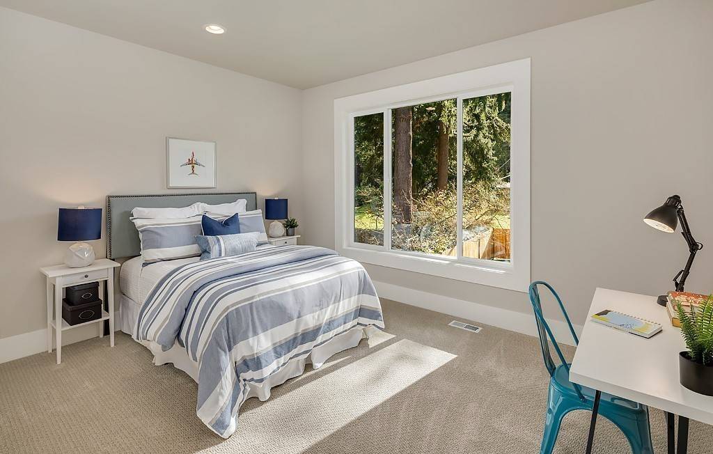 Secondary bedroom with a desk and backyard views.