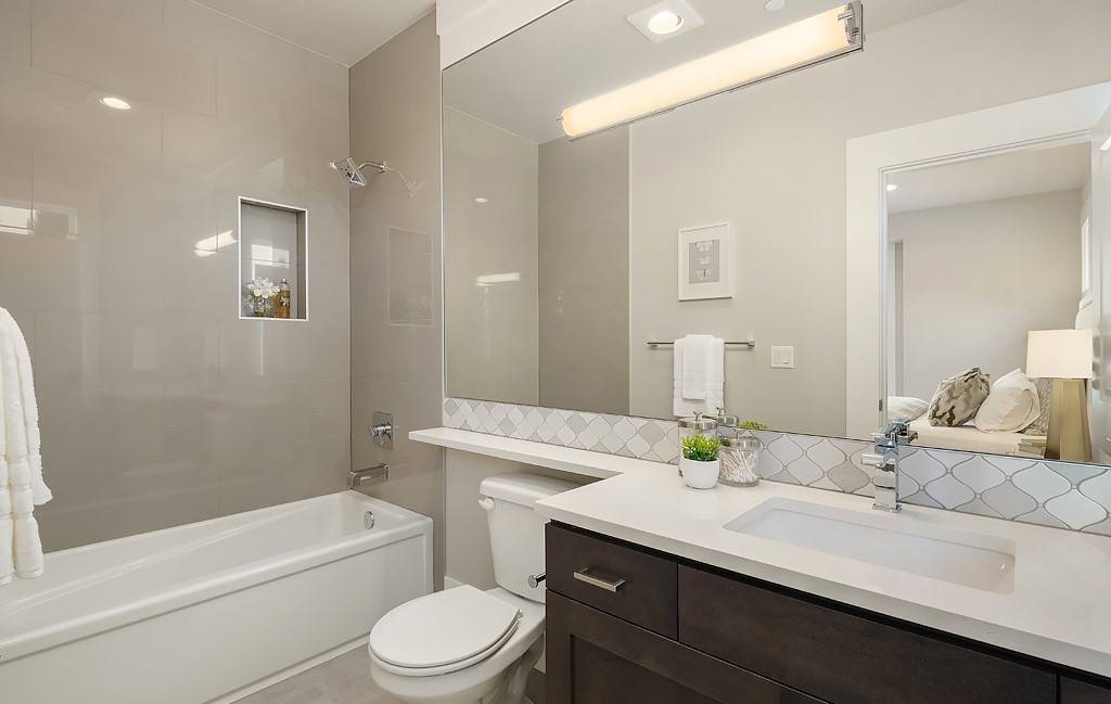 Bathroom with a dark wood vanity, a toilet, and a tub and shower combo.