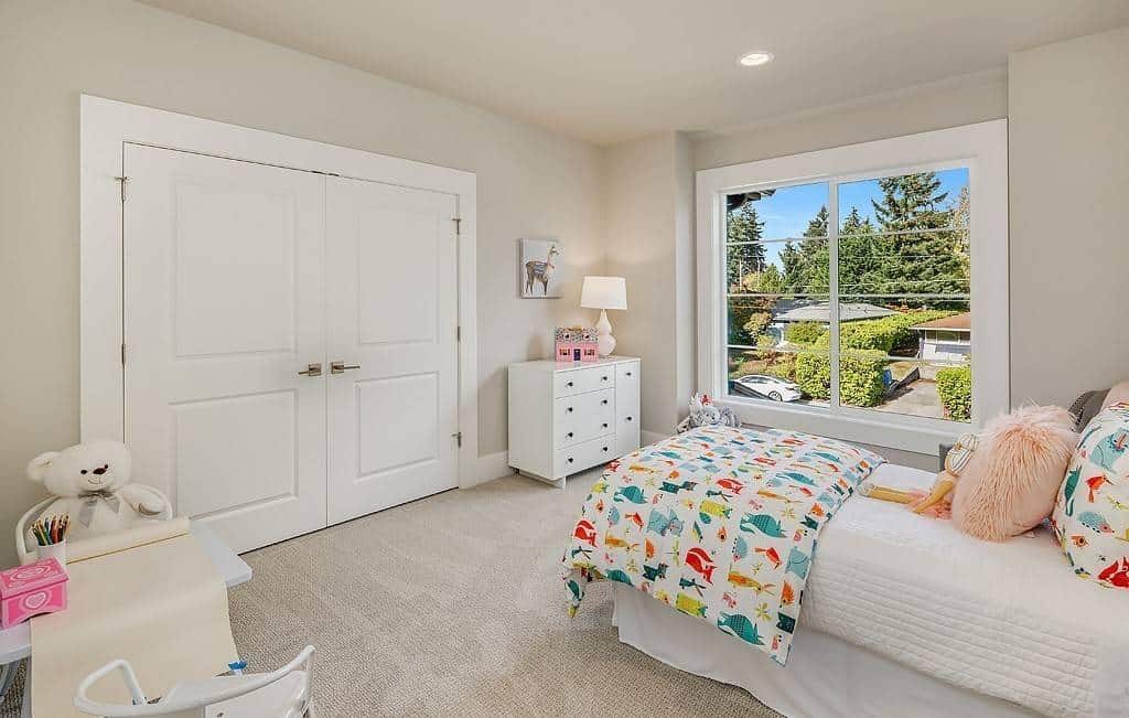 Secondary bedroom with carpeted floor and a large walk-in closet concealed behind the white double doors.