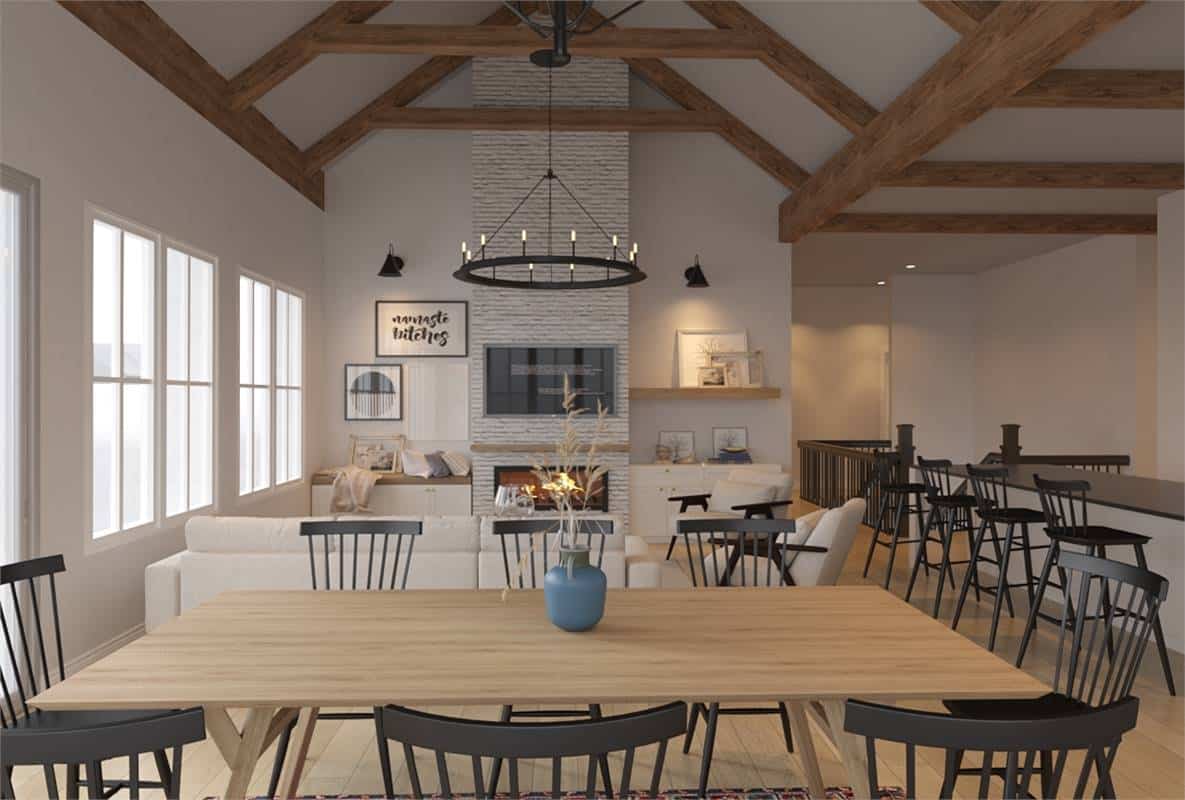 Dining area with a wooden dining set and a cathedral ceiling that spans through the living room.