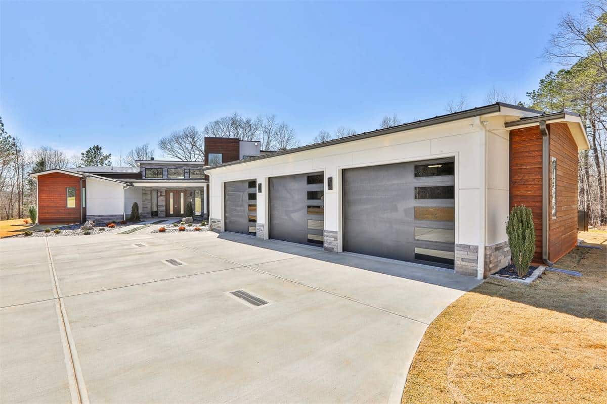 Front view of the house showcasing the courtyard entry garage and covered entry porch with a French front door.