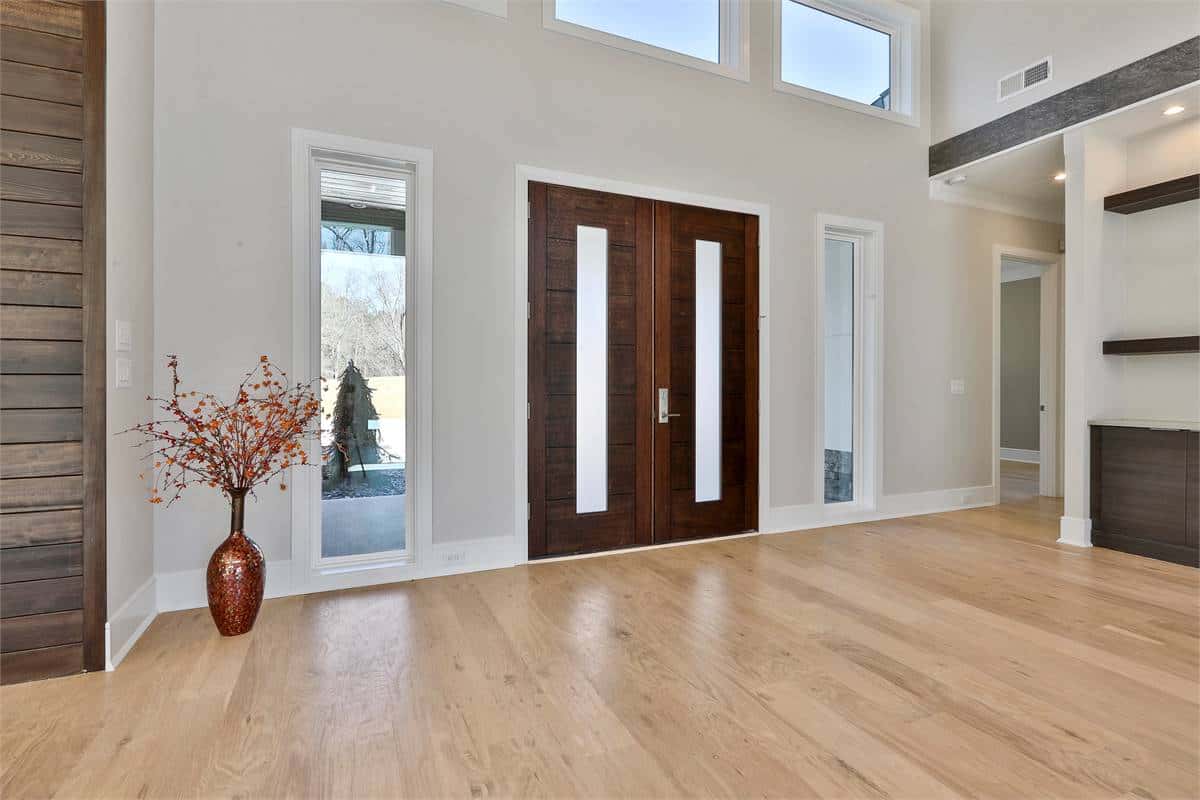 Front entry with a French front door, sidelights, and transom windows.