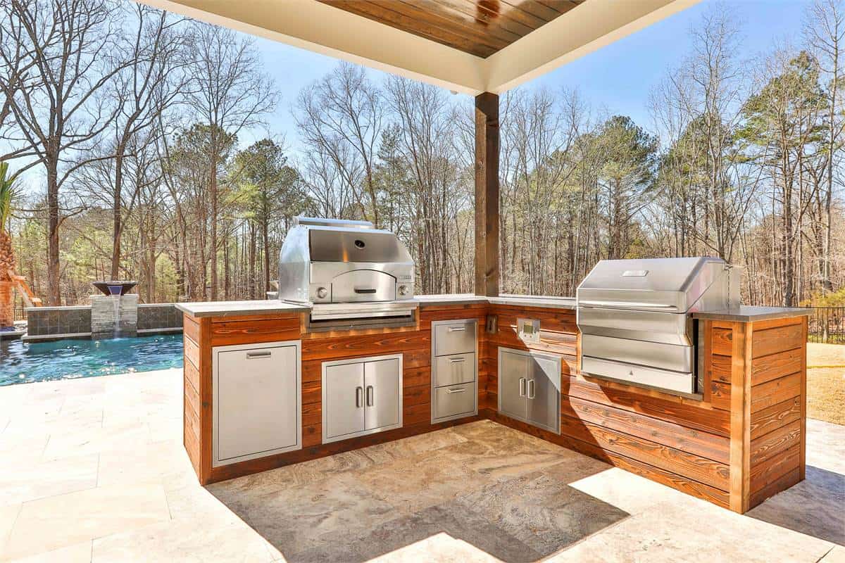 Outdoor kitchen with built-in grills overlooking the swimming pool.
