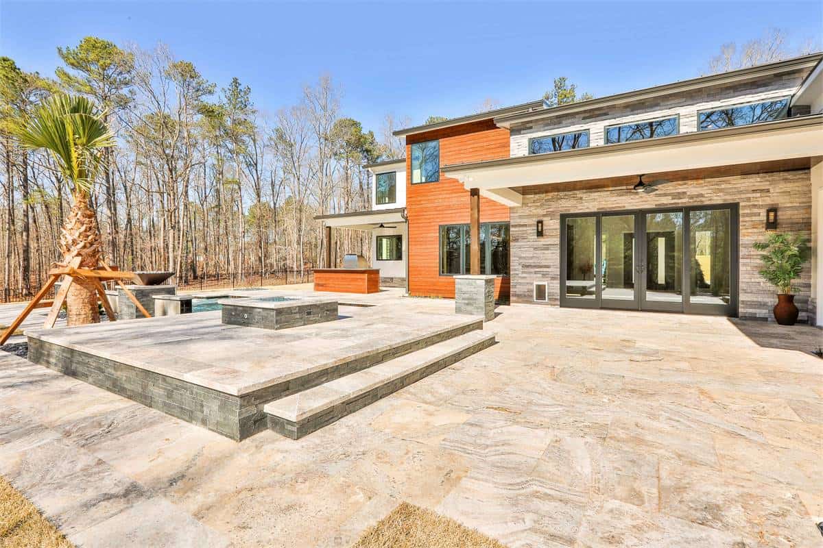 Rear view of the home showcasing the expansive patio and pool terrace.