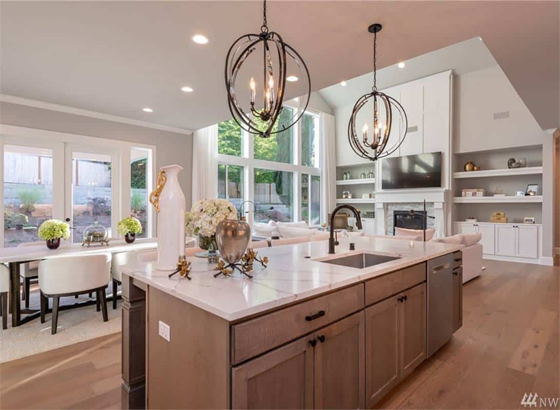Kitchen island with a sink and a view of the great room and breakfast nook.