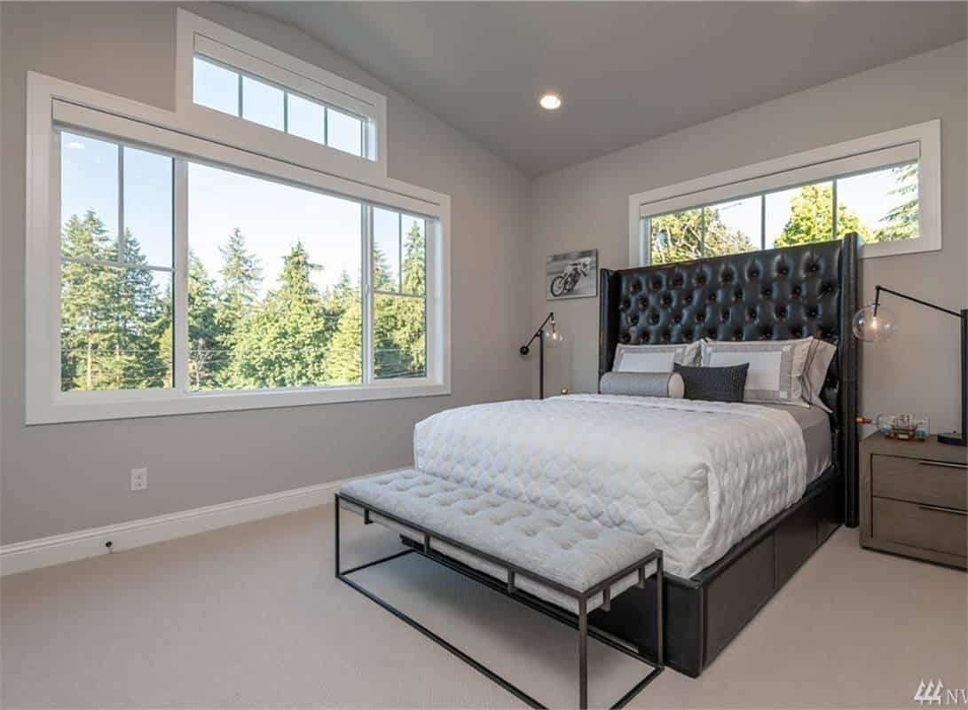 Secondary bedroom with a leather tufted bed, wooden nightstands, and a metal cushioned bench.
