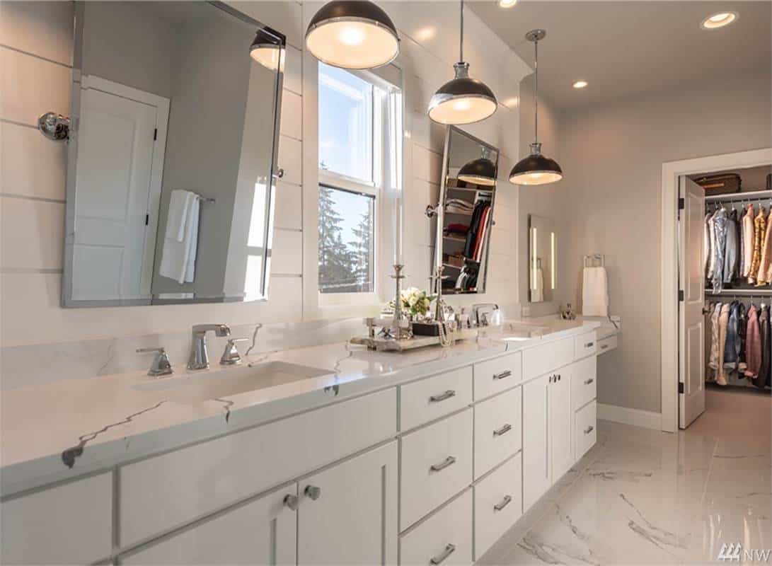 Primary vanity with two sinks, a marble countertop, and chrome-framed mirrors.