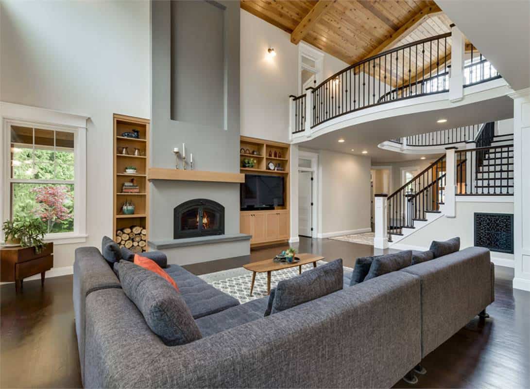 Great room with an L-shaped sofa and a fireplace flanked by wooden built-ins.
